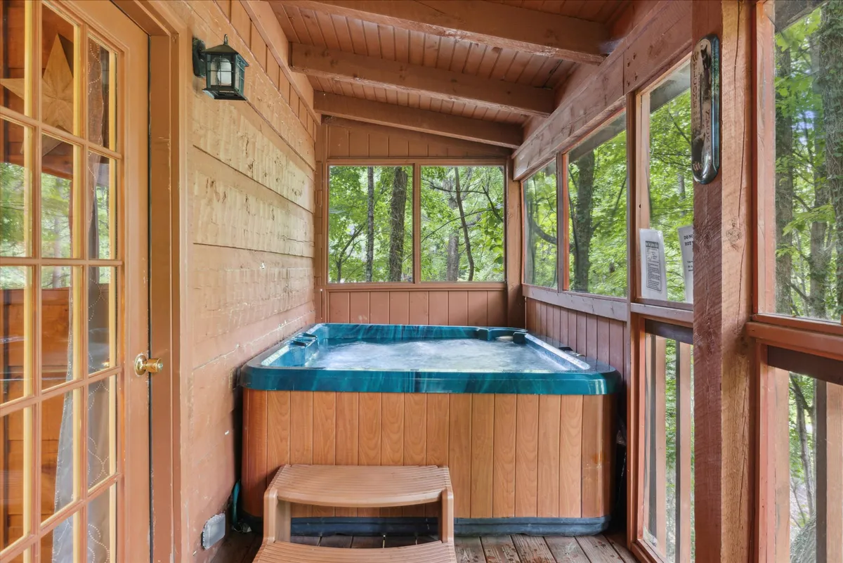 A cozy indoor hot tub set against warm wooden walls, with large windows overlooking the natural landscape. The space exudes serenity, inviting guests to relax and enjoy the views while soaking in the tub.